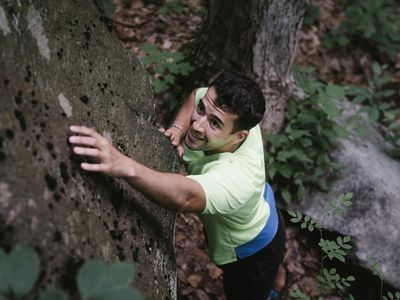 Man's hands gripping a resistance band, showing focus.